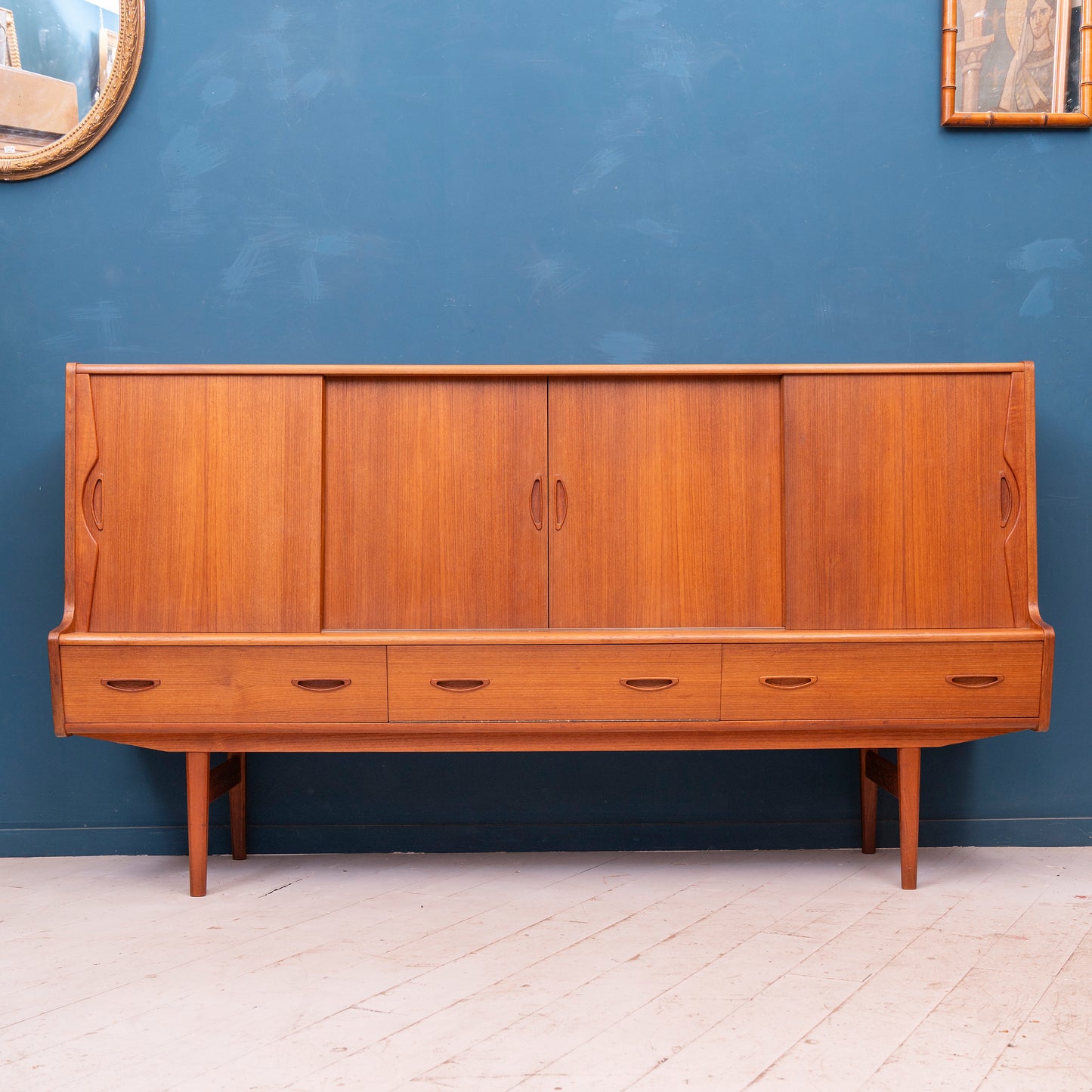Highboard danese in legno di teak risalente agli anni '60. Mobile credenza con 4 ante, 3 cassetti esterni e 4 cassetti interni, di manifattura danese.