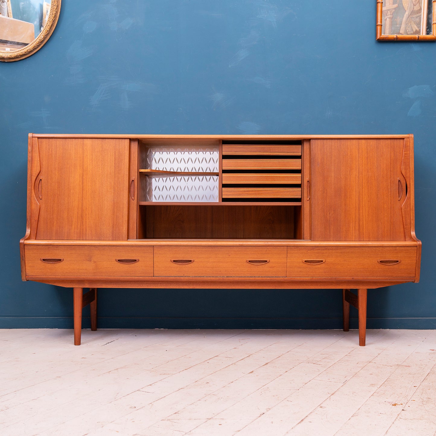 Highboard danese in legno di teak risalente agli anni '60. Mobile credenza con 4 ante, 3 cassetti esterni e 4 cassetti interni, di manifattura danese.
