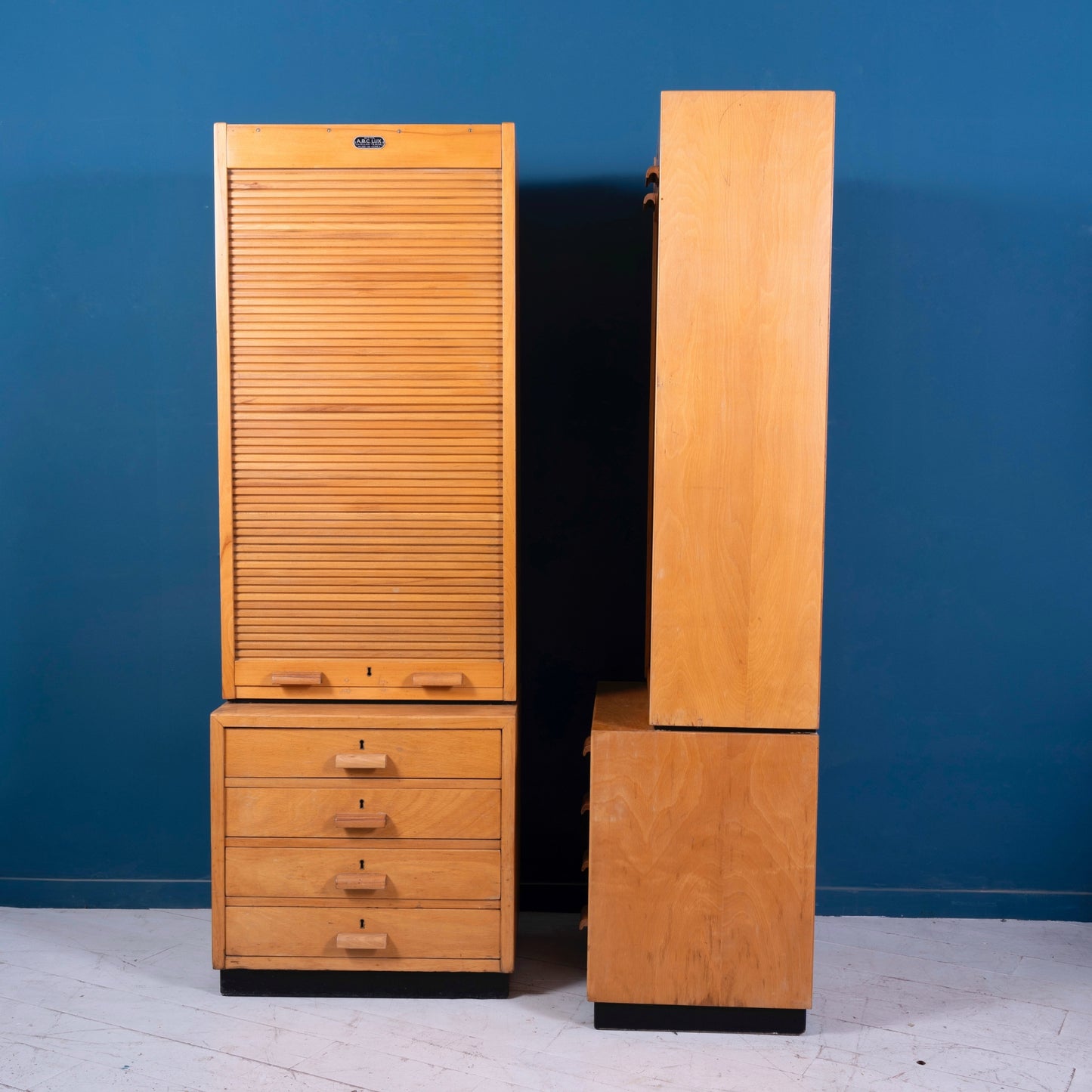 Fronte e fianco della Coppia di mobili da ufficio a serrandina in legno di faggio con 4 cassetti della marca A.B.C. LUX, risalente agli anni '50.