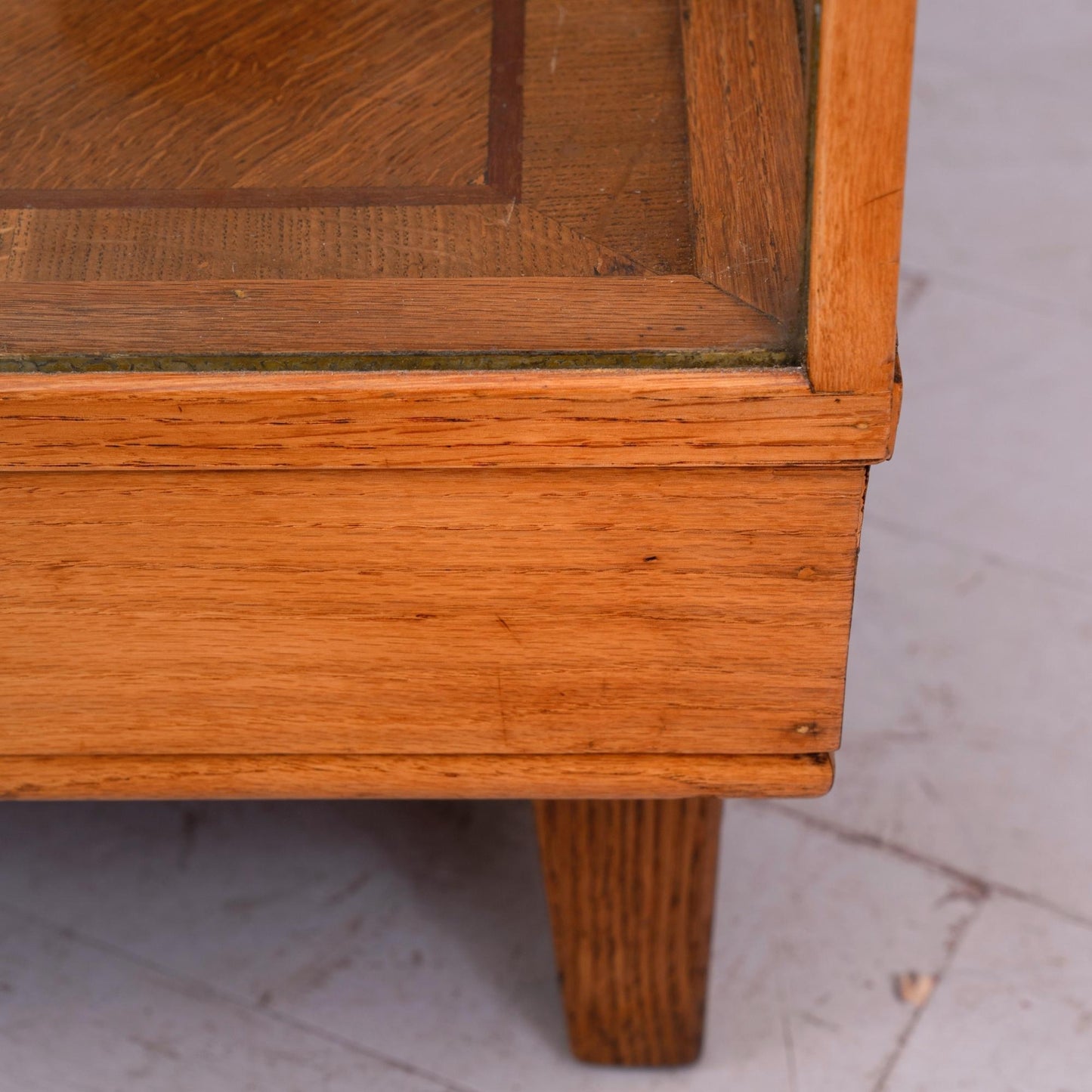 Dettaglio base Bancone vetrina inglese in legno di rovere, risalente alla prima meta del '900, con due mensole e ante scorrevoli in vetro. Riporta la targhetta originale "David S. Butler ltd office equipment specialists Derby".