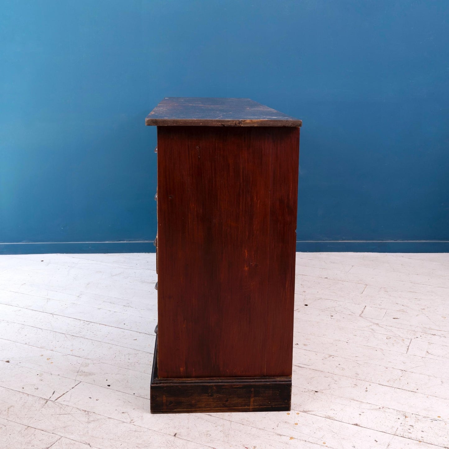 Dettaglio fianco Cassettiera industriale in legno di abete dipinto, risalente alla prima meta del '900. Il bancone è composto da 20 cassetti.