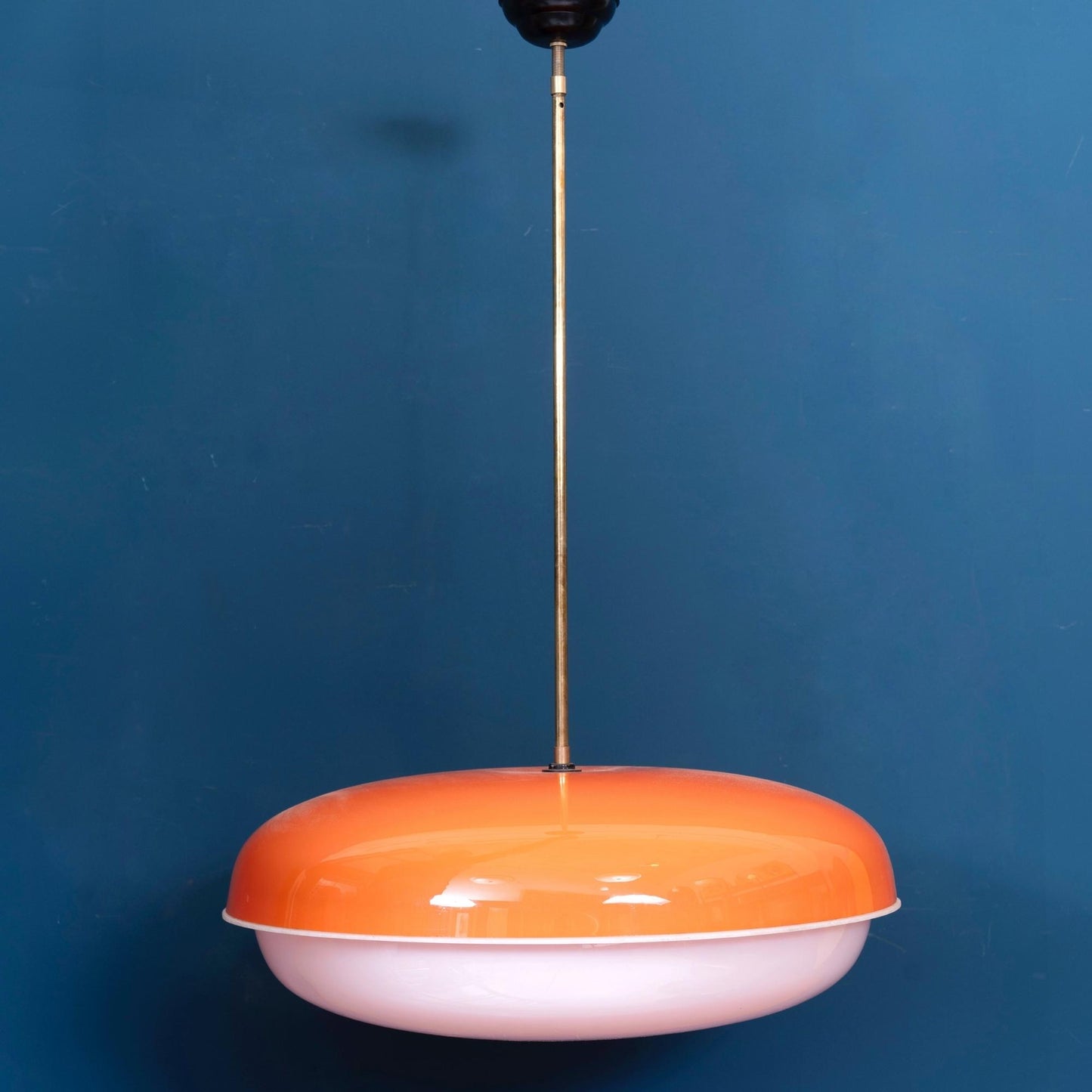 Lampada a sospensione in plexiglass arancione e bianca con inserto in ottone, risalente agli anni ’60.