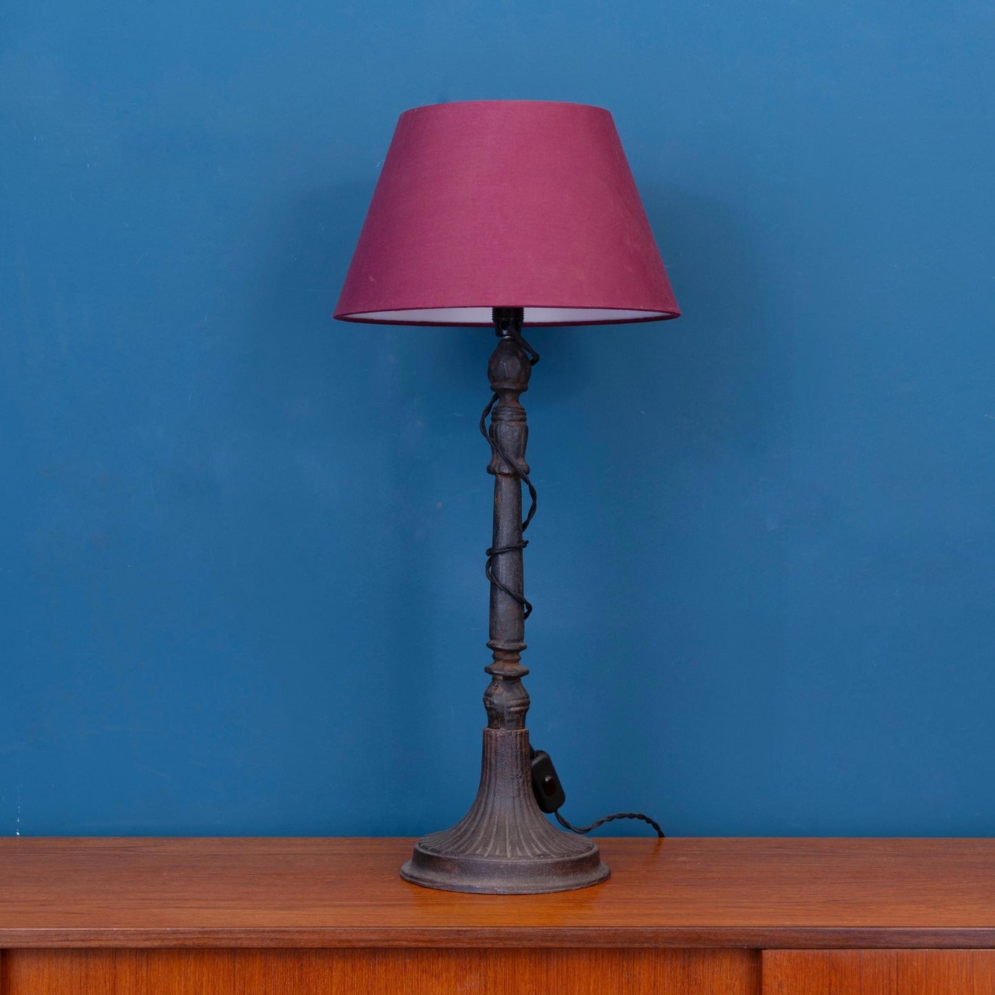 Lampada da tavolo francese in ghisa con paralume conico bordeaux, risalente alla fine dell’800.