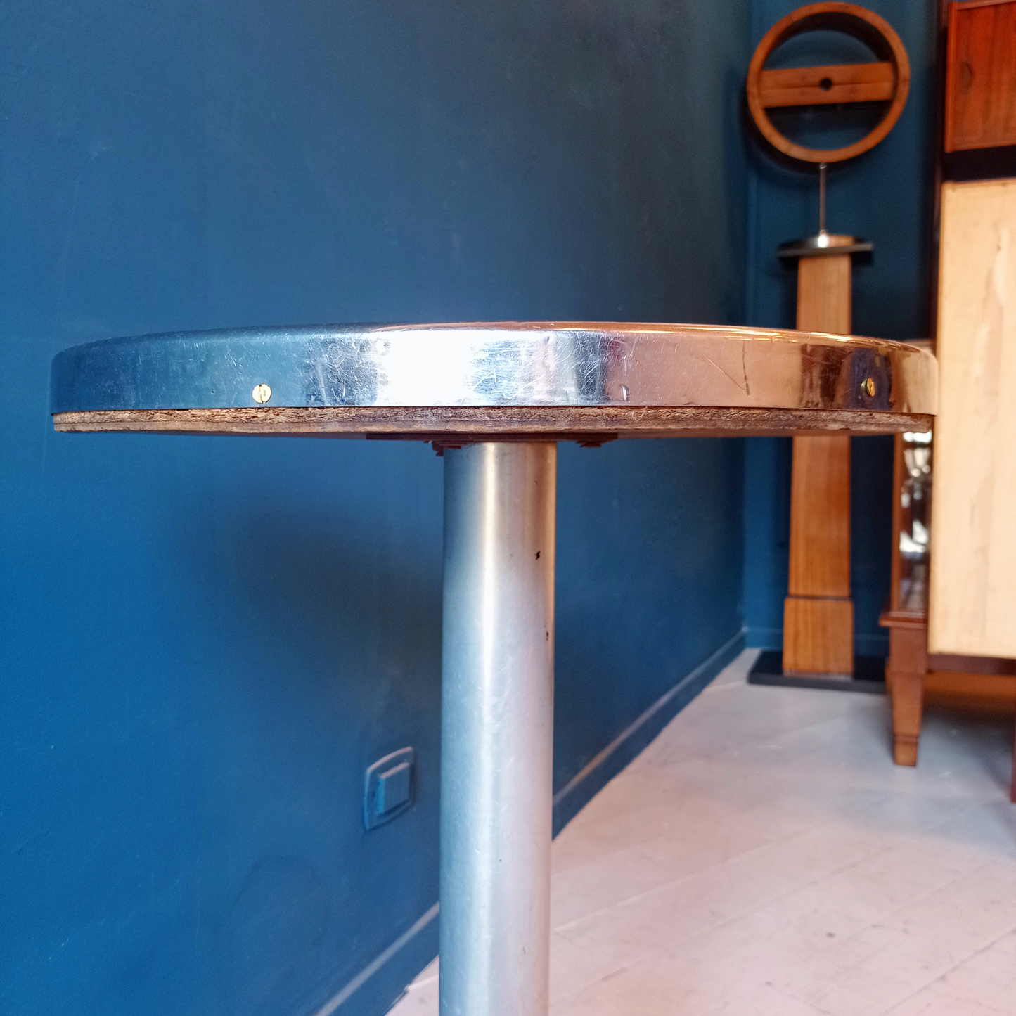 Dettaglio piano tavolino da bistrot francese vintage, risalente agli anni '30. Piano in formica rossa bordata in alluminio, gamba in alluminio e base in ghisa.